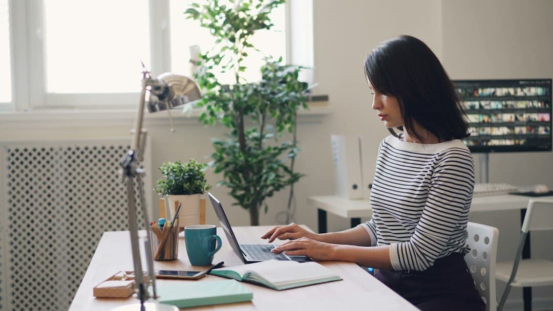 Professional working at a laptop at a tidy home office desk